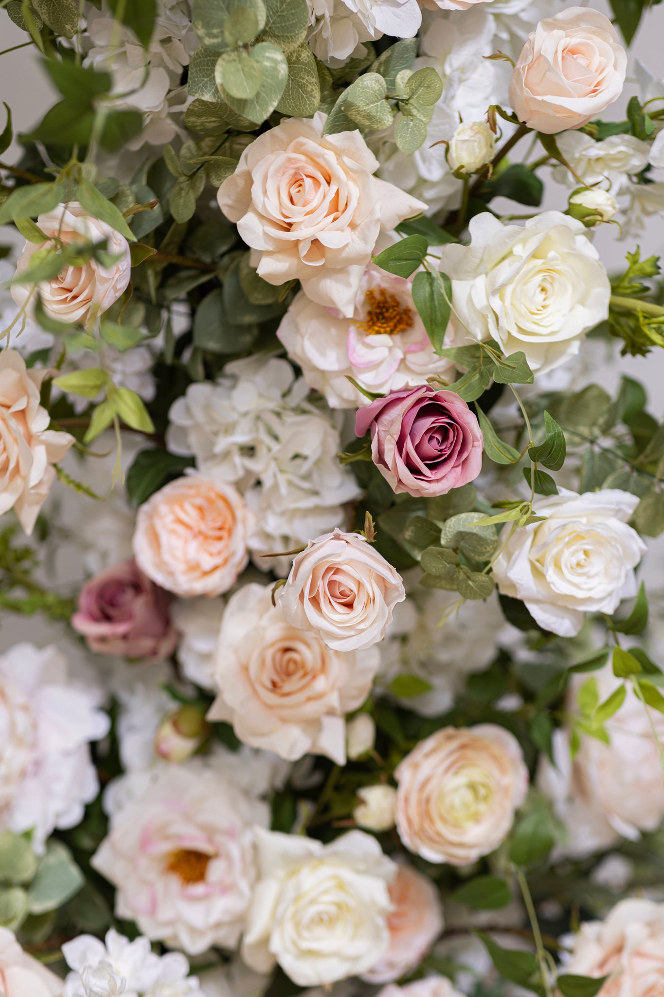 Romantic floral pillars for wedding ceremony in a color palette of blush, ivory, pale peach, and green.