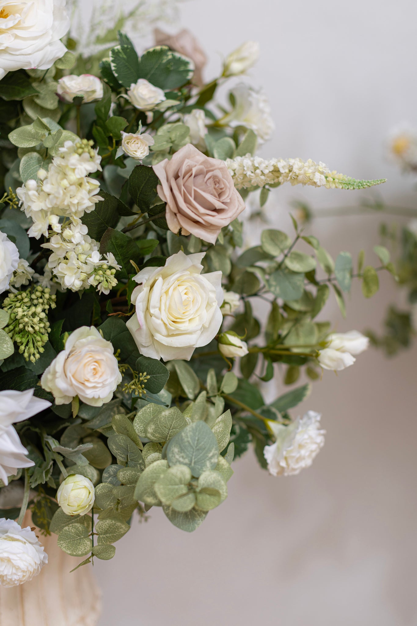 Classic wedding floral urns featuring lush flowers in a color palette of ivory, white, and taupe, accented with abundant greenery.