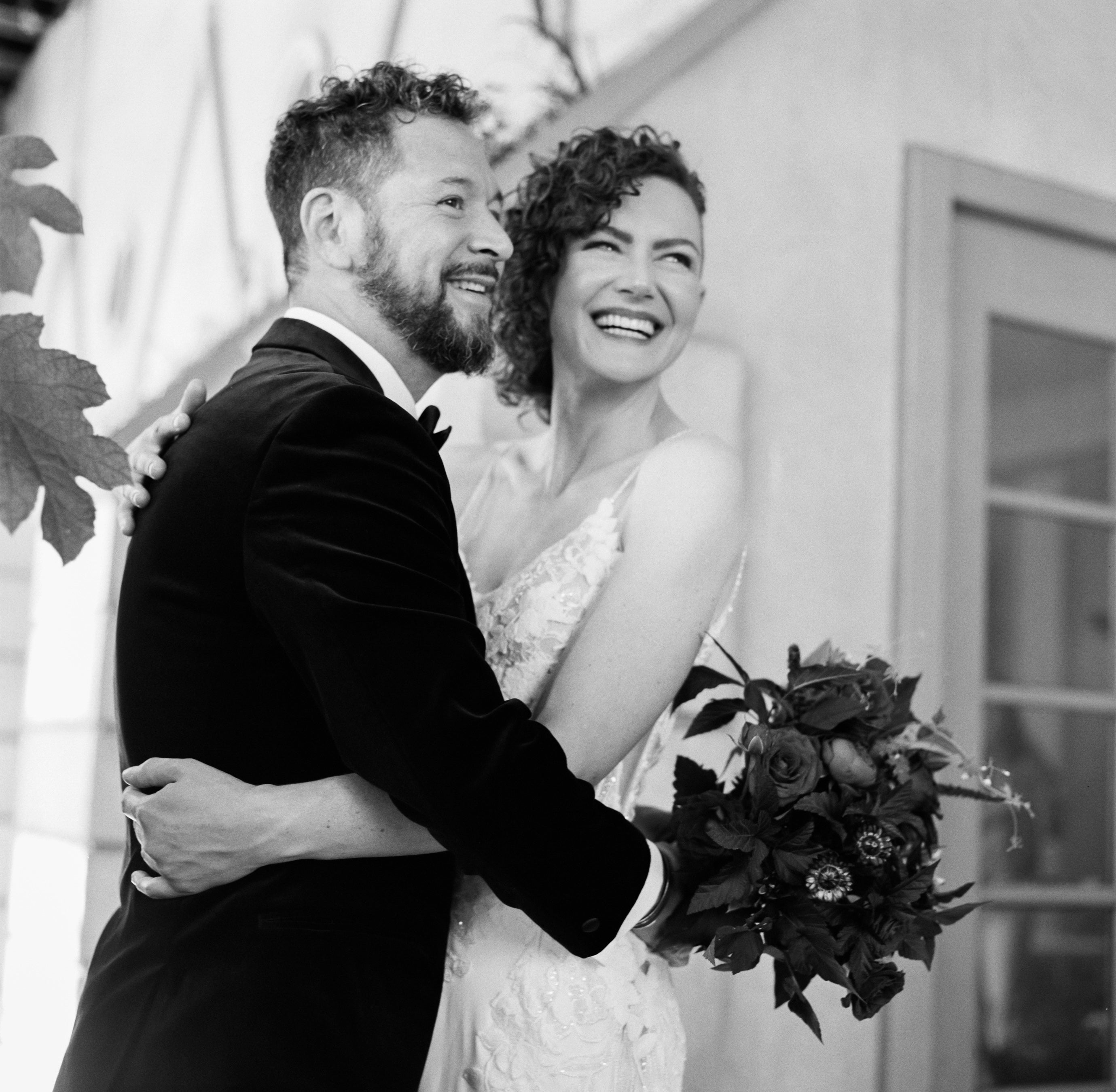 Happy couple in their wedding attire smiling at the camera