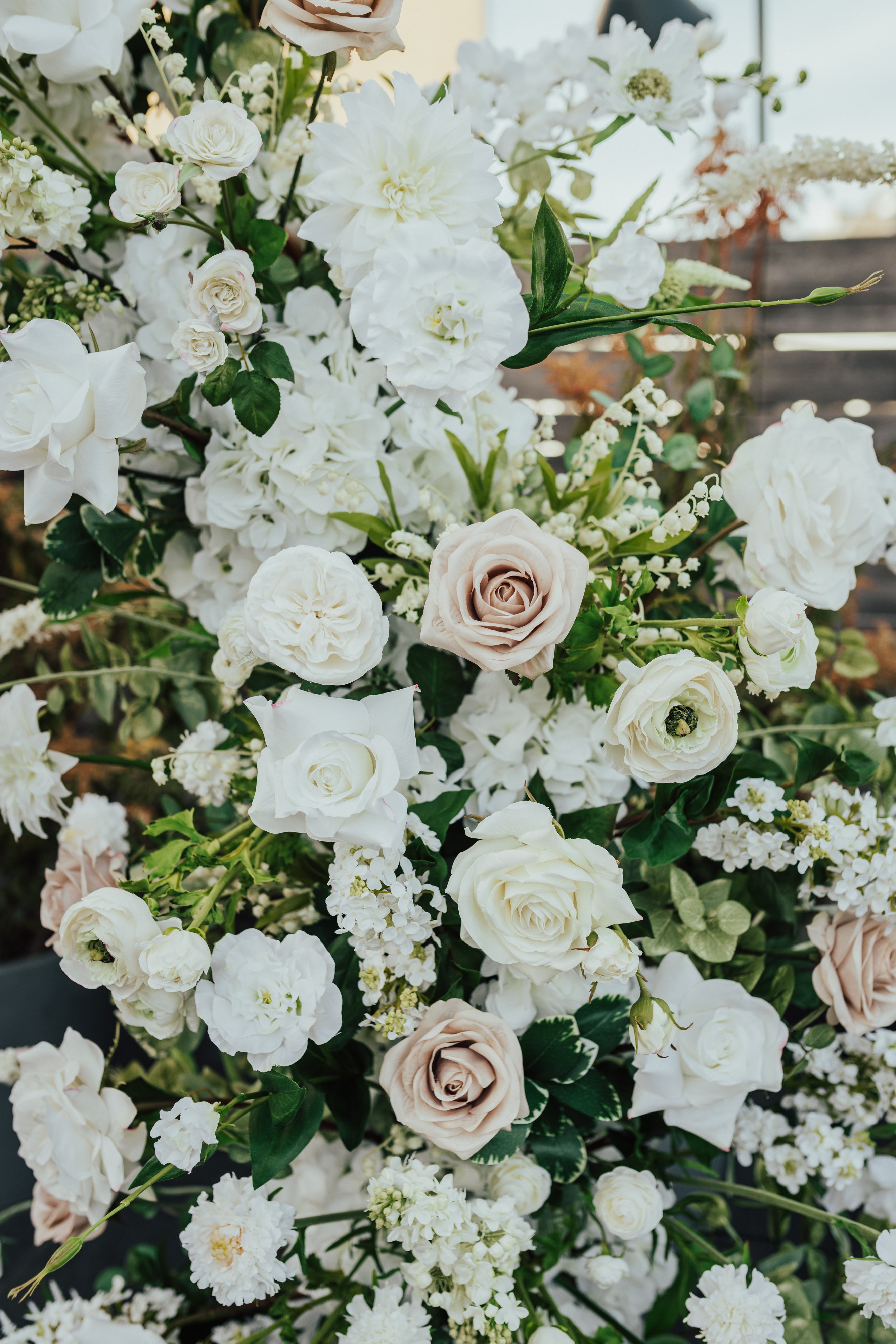 Delicate and romantic floral pillars for wedding ceremony, in a color palette of taupe, ivory, white, and green